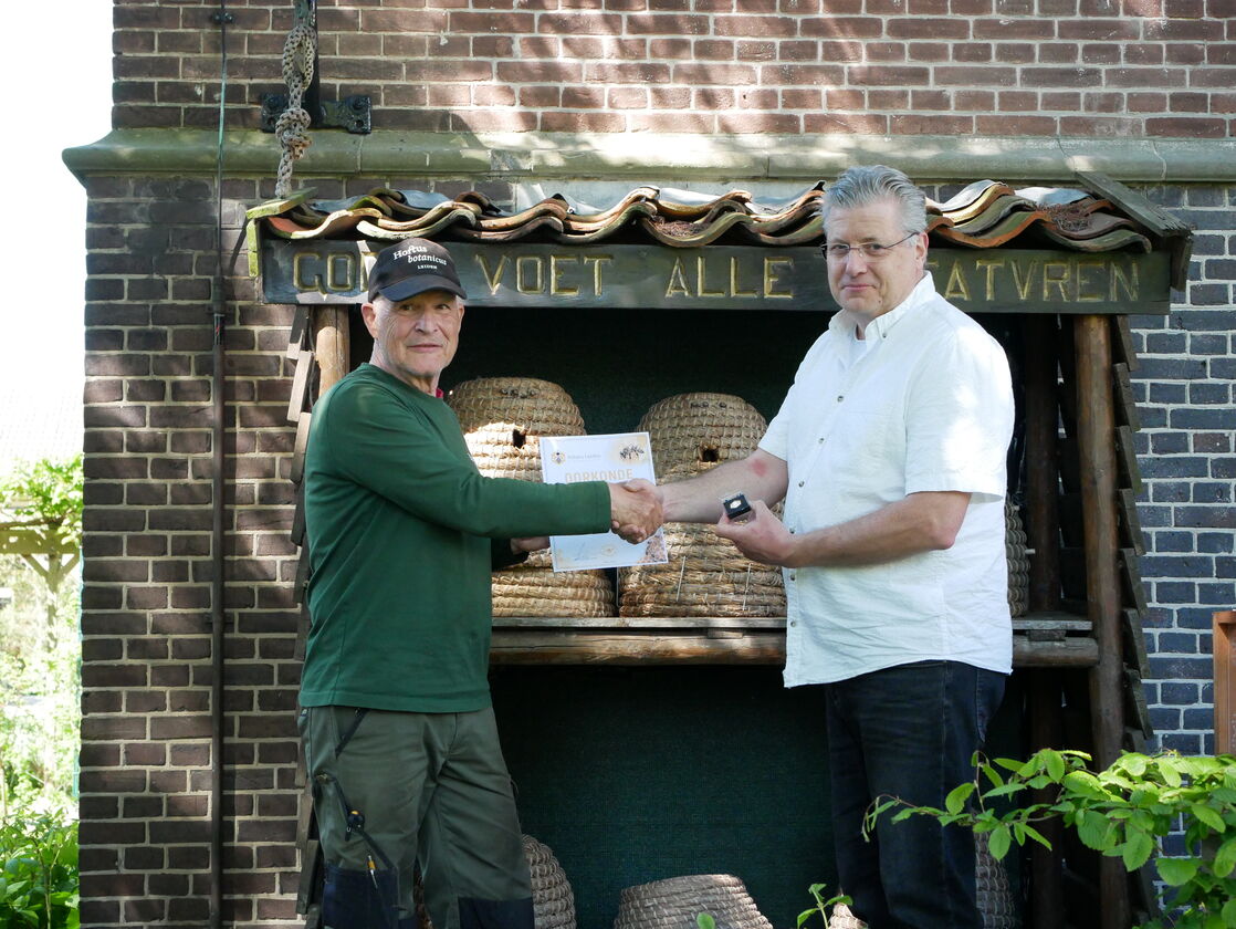 Hortusimker Fred Weber ontvangt de oorkonde uit handen van voorzitter Arjen Gerritsen. Foto: Hortus botanicus Leiden