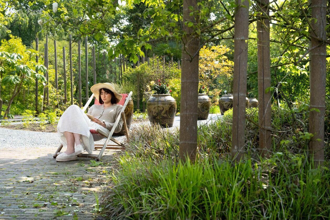 Student met boek in de tuin (credit Duco de Vries)
